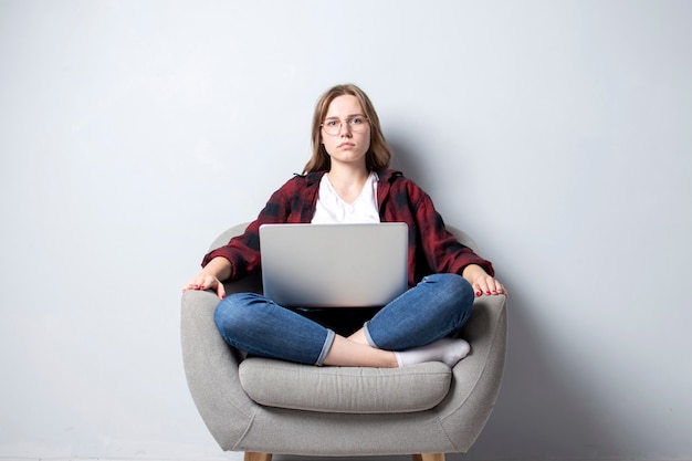 girl with a laptop sitting on a soft comfortable chair