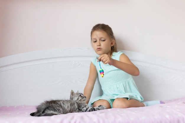 Girl with little kitten in the room