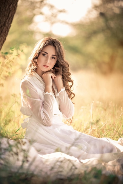 Girl with long hair in an old dress in the garden