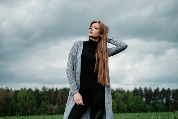 Girl with long hair standing in field in the wind Concept of freedom and passion