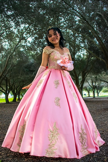 Girl with makeup and hairstyle in a princess dress in the middle of a park and green trees