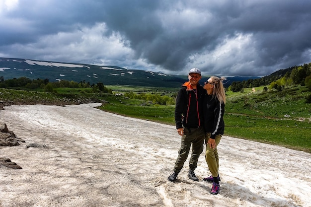 A girl with a man on a glacier on the snowy plateau of Lagonaki in Adygea Russia 2021