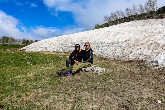 A girl with a man near a glacier on the LagoNaki plateau Snow in Adygea Russia 2021