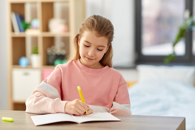 Photo girl with notebook and marker drawing at home