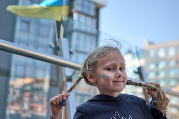 Girl with painted Ukraine flag yellow and blue Stop the war and the power of Ukraine patriotism