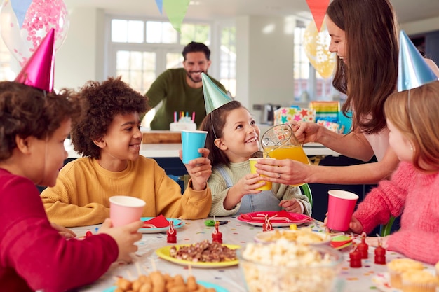 Girl With Parents And Friends At Home Celebrating Birthday With Party