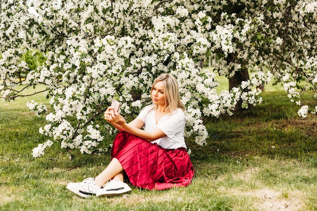 A girl with a phone in her hand takes pictures of herself, selfies