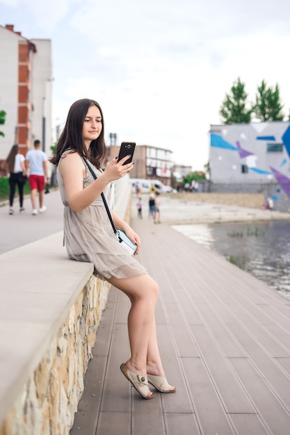 Girl with phone on pier.