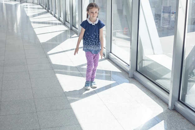 A girl with pigtails walks through a deserted passage