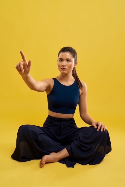 Girl with pony tail practicing yoga at studio