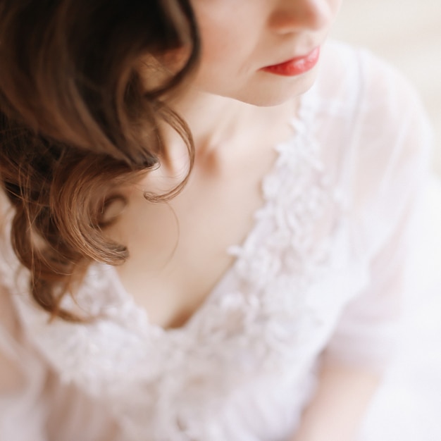 Girl with red lips in profile. Close-up portrait of a young woman. Wedding details. Morning of the bride.