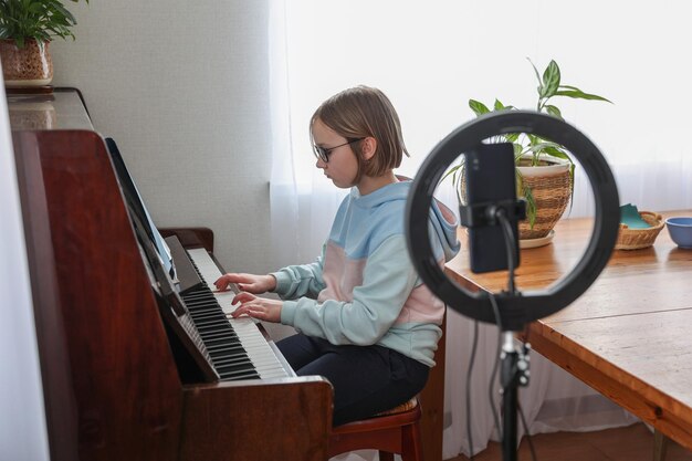 Girl with a ring lamp for a smartphone distance education