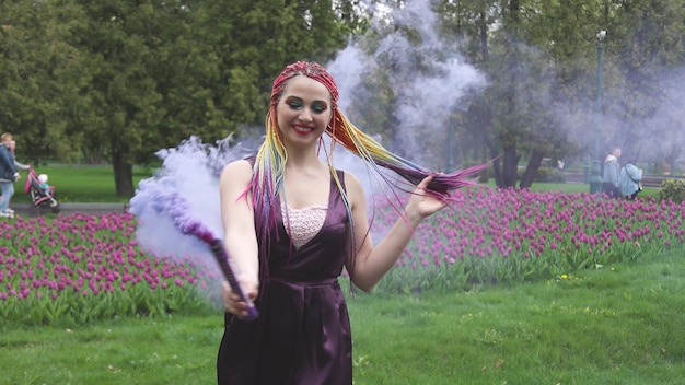 A girl with a smile with bright makeup and colored braids