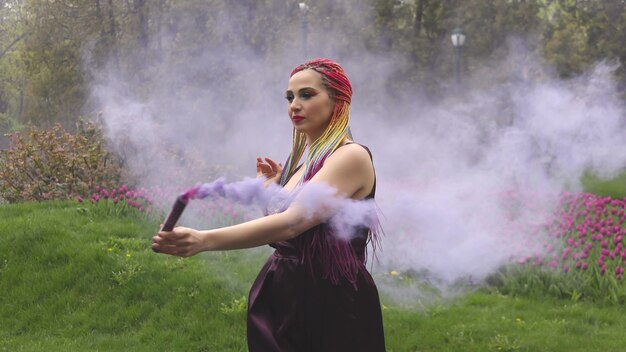 A girl with a smile with bright makeup and colored braids