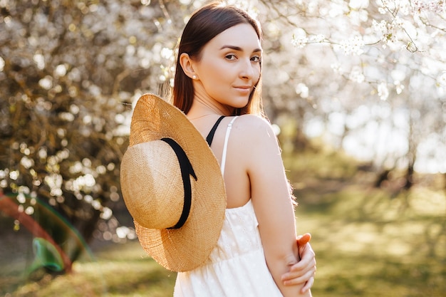 Girl with a straw hat in the spring in the park