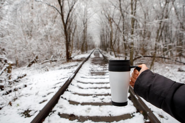 Girl with a thermos cup in winter