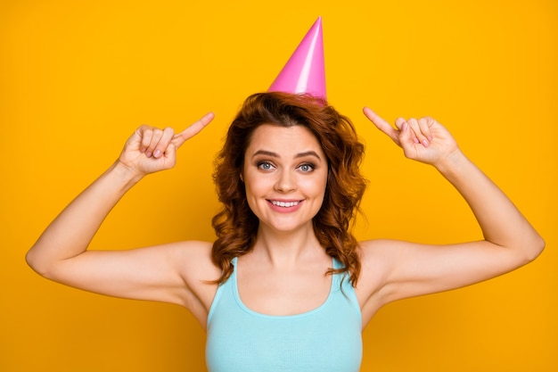 girl with trendy hairstyle and party hat isolated on orange