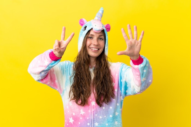 Girl with unicorn pajamas over isolated background counting seven with fingers