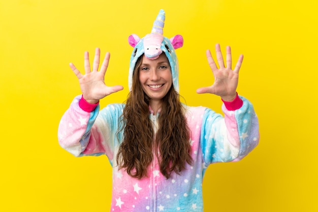 Girl with unicorn pajamas over isolated background counting ten with fingers