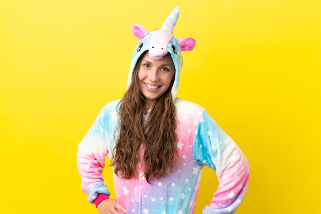 Girl with unicorn pajamas over isolated background laughing