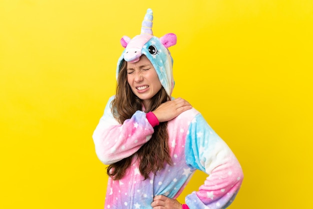 Girl with unicorn pajamas over isolated background suffering from pain in shoulder for having made an effort