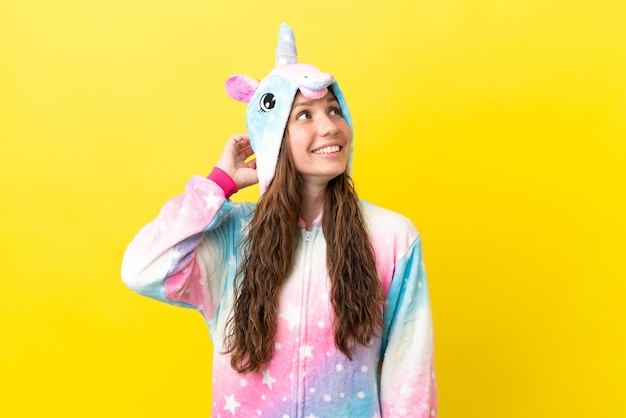 Girl with unicorn pajamas over isolated background thinking an idea