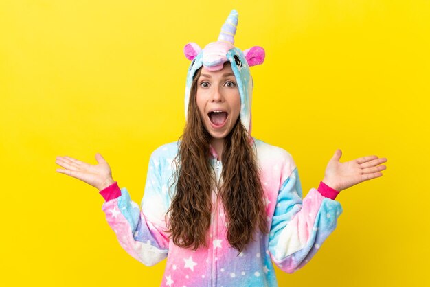 Girl with unicorn pajamas over isolated background with shocked facial expression