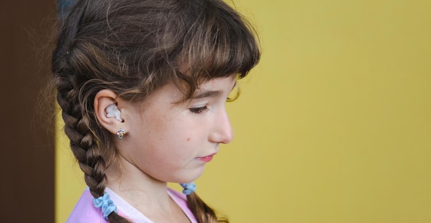 Girl with a warming therapeutic cotton swab in the ear with a sad and tearful face is holding her ear Ear pain otitis media swelling of cheek gums toothache children's surgery otolaryngology