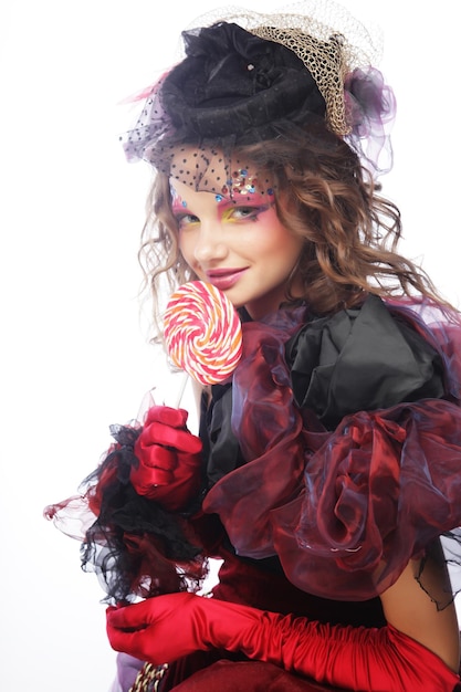 Girl with with creative makeup holds lollipop