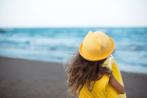 A girl with a yellow inflatable circle on the seashore Relaxing on the beach summer travel