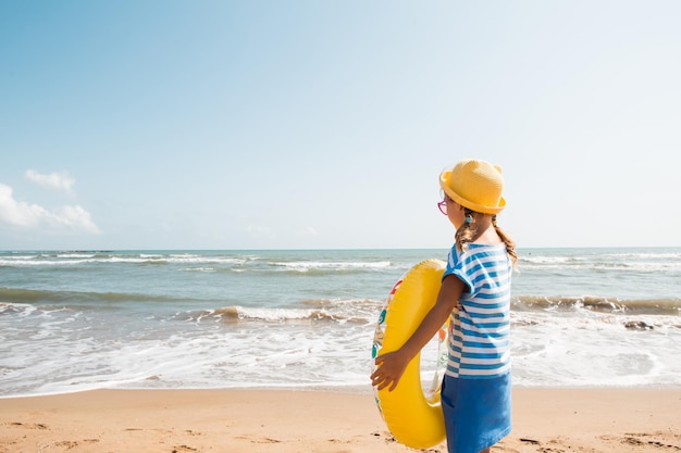 A girl with a yellow inflatable circle on the seashore Relaxing on the beach summer travel