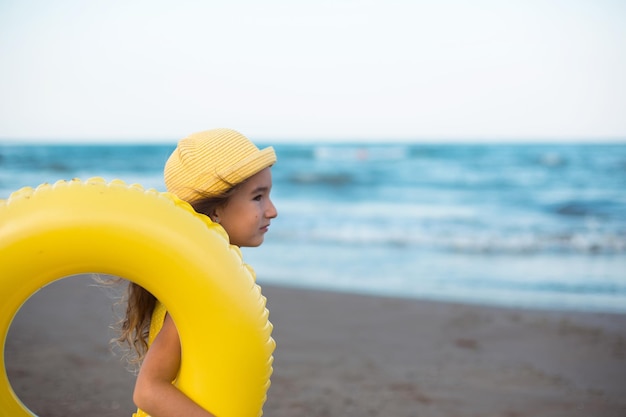 A girl with a yellow inflatable circle on the seashore Relaxing on the beach summer travel