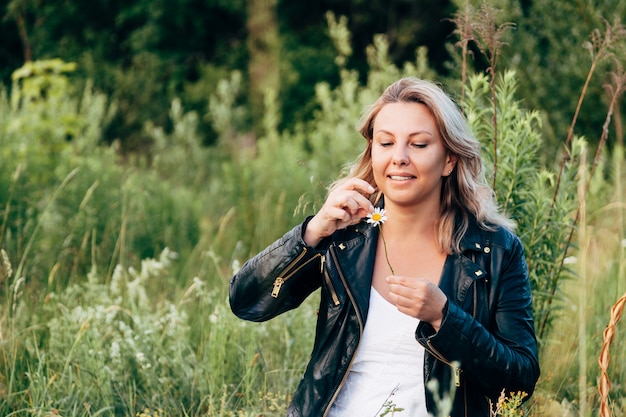 Girl wondering on a Daisy in a summer meadow