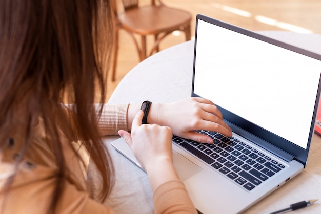 girl at workplace looks at the clock. expectations and lateness. place for text on laptop.