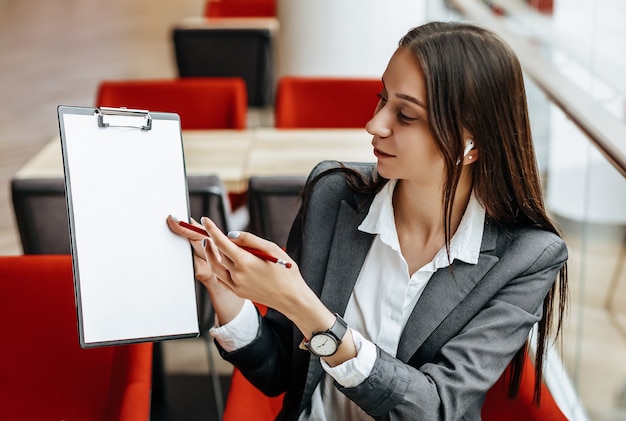 Girl works on a laptop in the workplace. Businesswoman shows and explains the goals and objectives for the business. Successful woman creates a startup and makes decisions.