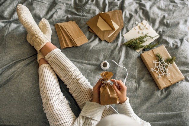 Girl wrapping gifts with Christmas decoration