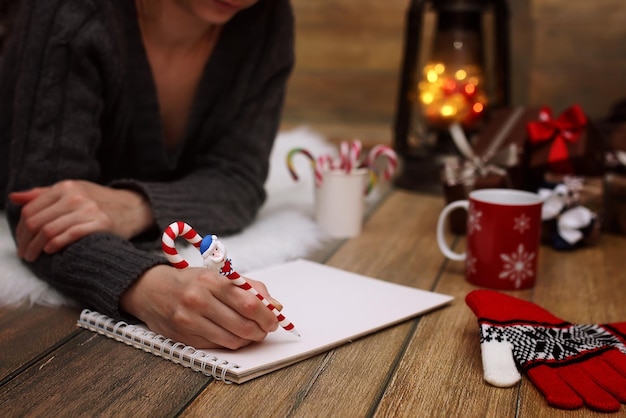 Girl writes pen on a piece of paper Christmas wishes and letters to Santa