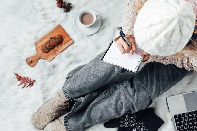 A girl writing winter words on a note book for winter concept background