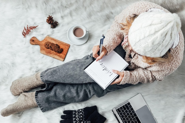 A girl writing winter words on a note book for winter concept background