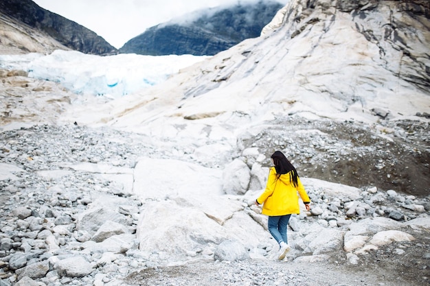 The girl in a yellow jacket running outdoor in Norway mountains Active woman enjoys freedom