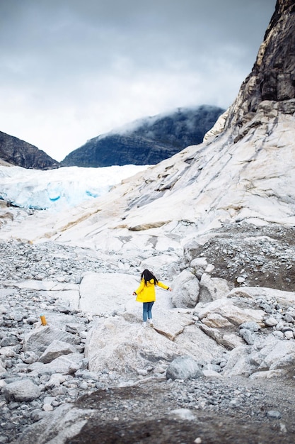 The girl in a yellow jacket running outdoor in Norway mountains Active woman enjoys freedom