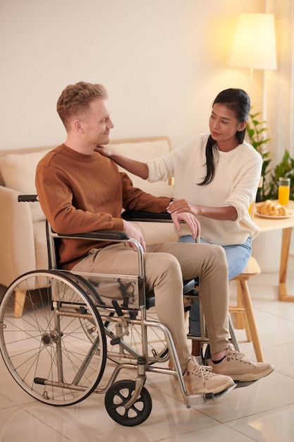 Girlfriend Supporting Young Man in Wheelchair