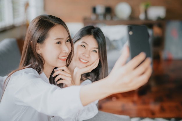 girlfriends taking selfies together at home