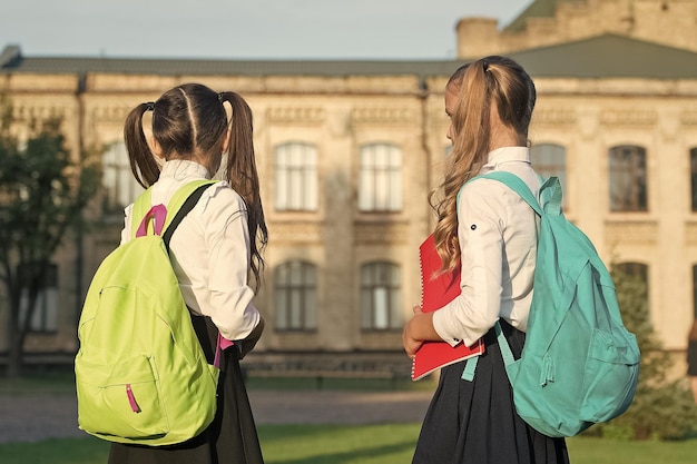 Girls backpacks study together in school fist day at school concept