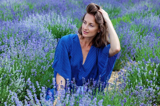 Girls in a blue dress are photographed in purple lavender flowers on a field