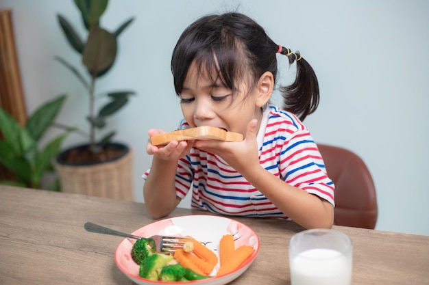 Girls eat breakfast on the table in the living room