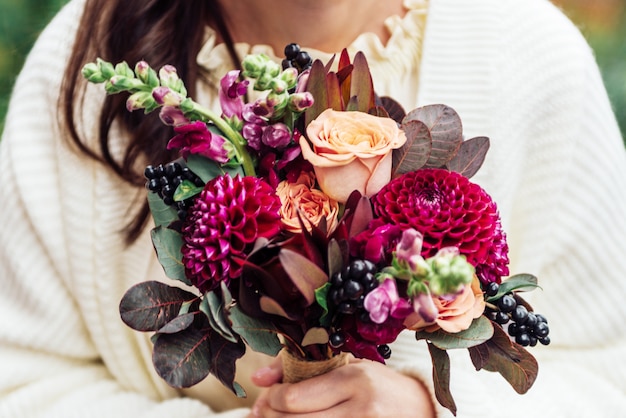 Girls hands holding bouquet flowers in rustic boho style