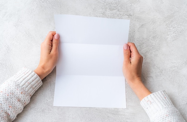 Girls hands holding white molded sheet of paper