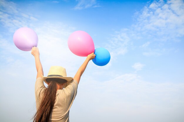 Girls hold balloons in blue, pink and purple. And raised his arms in the sky