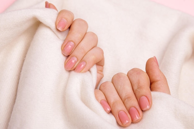 Girls nails with regrown gel coating untidy and wellgroomed hand with fresh manicure gentle nude coa